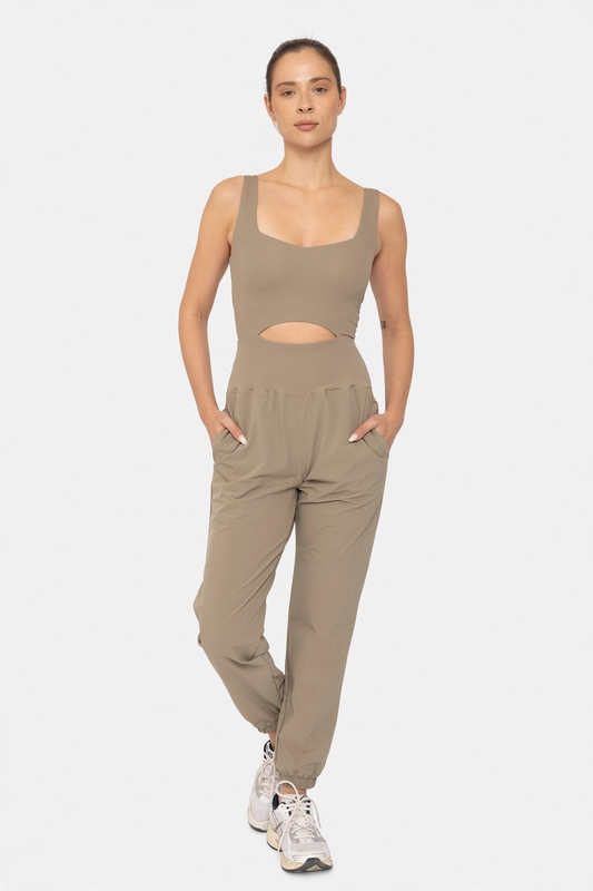 Woman wearing a beige tank top and pants on a white background