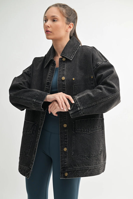 Woman wearing a black denim jacket on a white background